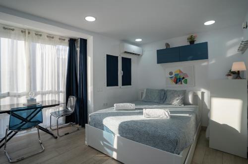 a bedroom with a bed and a table and a desk at APARTAMENTOS EL CARMEN Carihuela PLAYA in Torremolinos