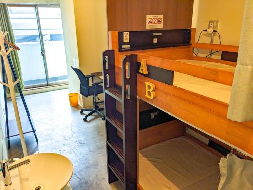Pokój z łóżkiem piętrowym i biurkiem w obiekcie Hostel JIN - Weekly Appartment in Osaka w Osace
