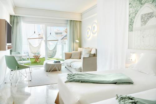 Iberostar Selection Marbella Coral Beach في مربلة: غرفة نوم بيضاء مع سرير وغرفة معيشة