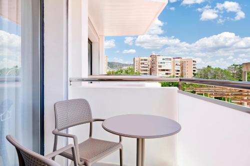 a balcony with a table and chairs and a window at tent Torremolinos in Torremolinos