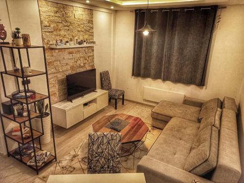 ein Wohnzimmer mit einem Sofa und einem TV in der Unterkunft Milmari Resort N56 Kopaonik free wellnes&spa in Kopaonik
