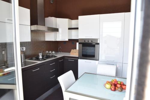 una cocina con armarios blancos y un bol de fruta en una mesa en Perla marina, en Porto Empedocle