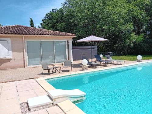 une piscine avec des chaises et un parasol dans l'établissement La Tissonnière Oasis d Exception entre Mer Alpilles et Luberon Spa et Piscine à 10 min d Aix en Provence, à Saint-Estève-Janson