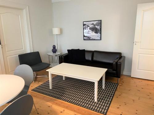 een woonkamer met een bank en een tafel en stoelen bij City Apartments 114 in Kopenhagen