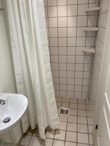 een badkamer met een wit douchegordijn en een wastafel bij City Apartments 114 in Kopenhagen