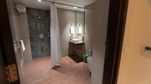 e bagno con doccia, servizi igienici e lavandino. di 7 Apple Hotel Aurangabad ad Aurangabad