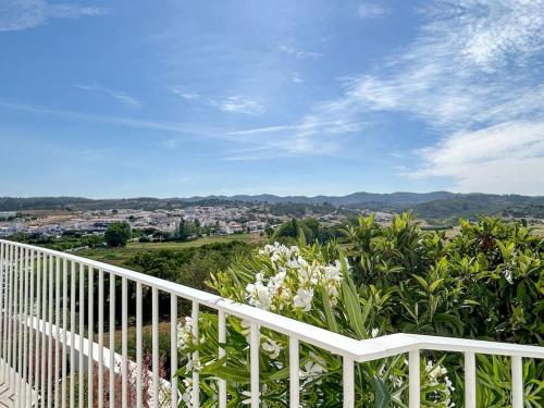 a white balcony with a view of a city at Casa das Piteiras nº3 - Aljezur in Aljezur