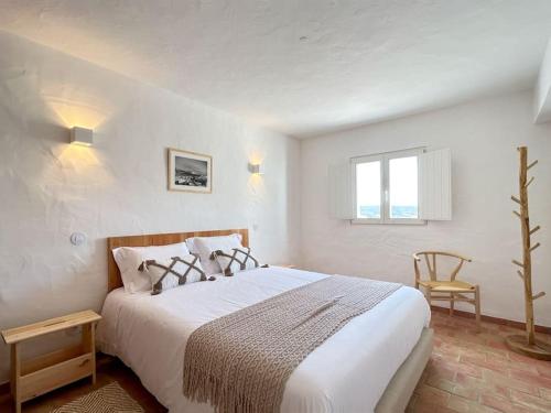 a white bedroom with a bed and a window at Casa das Piteiras nº3 - Aljezur in Aljezur