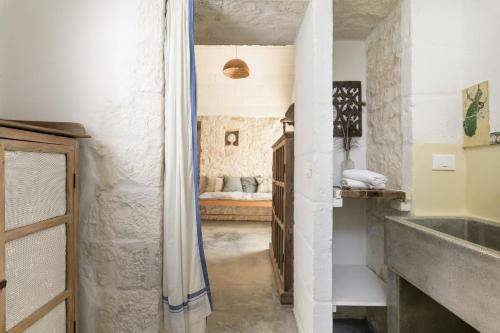 um corredor com uma cama num quarto em Trullo Solleone con piscine by Wonderful Italy em Carovigno