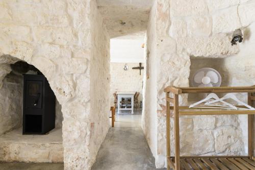 um quarto com uma parede de pedra com uma cama em Trullo Solleone con piscine by Wonderful Italy em Carovigno