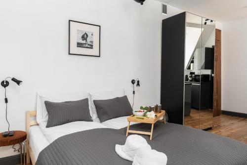 a bedroom with a white bed and a table at Apartments Poznań Strzałowa by Renters in Poznań