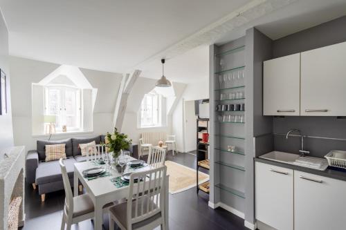 a kitchen and a living room with a table and chairs at L'Armateur - Appartement intramuros - plage - St Malo in Saint Malo