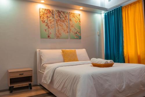 1 dormitorio con 1 cama y una pintura en la pared en GT Seaside Inn, en Oslob