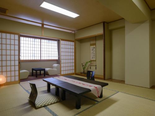 a room with a bed and a table and chairs at Ryokan Kohro in Kyoto