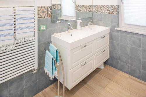 a bathroom with a white sink and a mirror at Villa Rosetta & Romeo Family Apartment in Costermano sul Garda