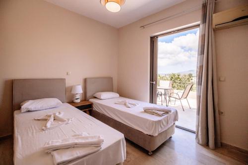 a hotel room with two beds and a balcony at Nadia Apartments B in Kalamaki