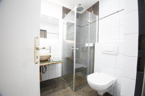 W łazience znajduje się toaleta i przeszklony prysznic. w obiekcie Captain Baack w mieście Nieblum