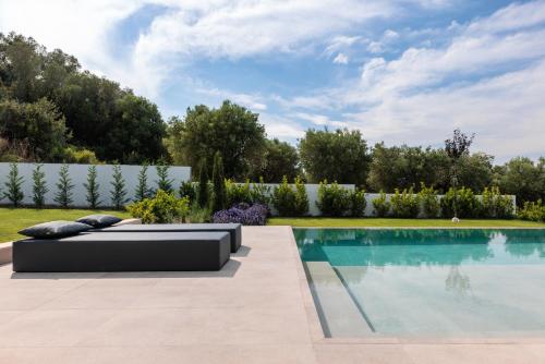 a pool in a backyard with a couch next to it at Five Senses Of Luxury in Kalandra