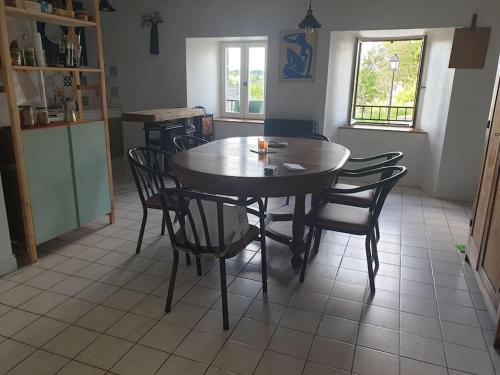 een eetkamer met een houten tafel en stoelen bij Appartement 6 pers sur l'Aubrac 