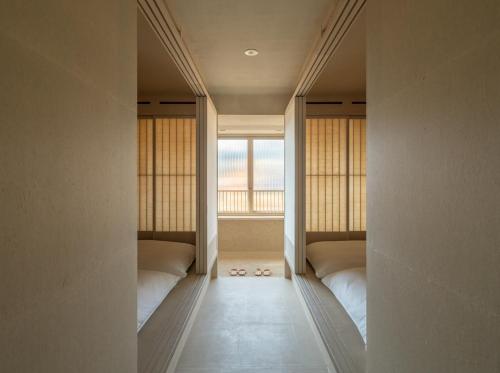 two beds in a room with a window at LOG in Onomichi