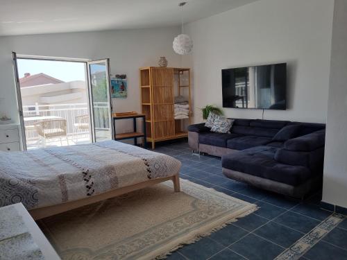 a living room with a bed and a couch at Rosemary Resort in Cesarica