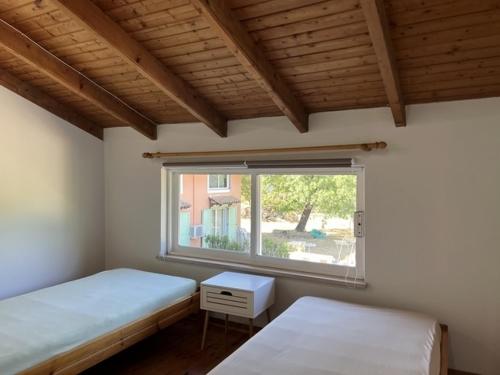 a bedroom with two beds and a window at Harmony House Corfu in Kynopiástai