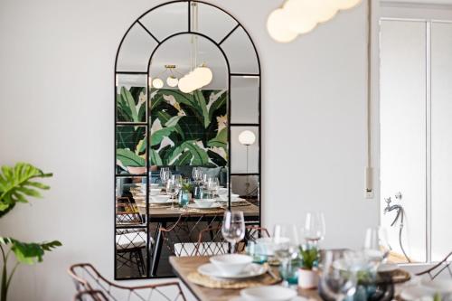 una sala da pranzo con tavolo di fronte a uno specchio di Arbio I Premium Penthouse Apartment Augsburg a Augusta (Augsburg)