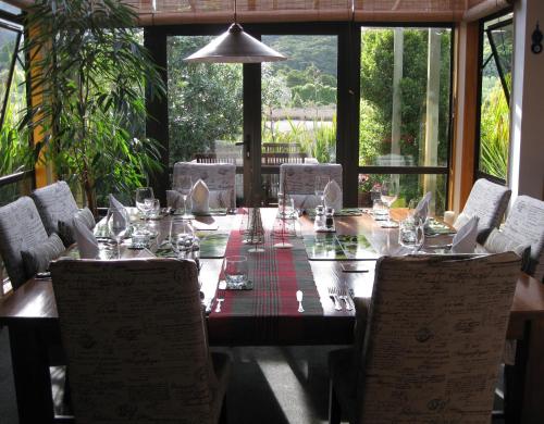 a dining room table with chairs and a table set for dinner at Twin Waters Lodge in Collingwood