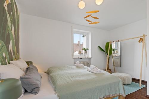 Cette chambre blanche dispose d'un lit et d'une fenêtre. dans l'établissement Arbio I Premium Penthouse Apartment Augsburg, à Augsbourg