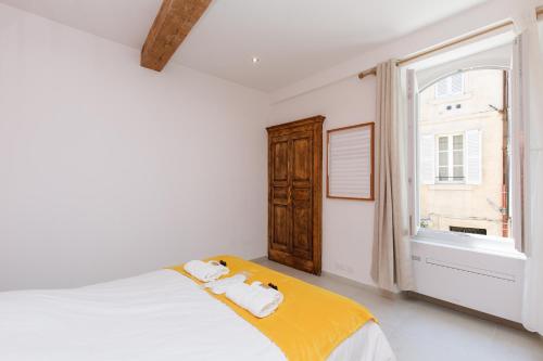 une chambre blanche avec un lit et une fenêtre dans l'établissement Le Cocon Saint Tropez YourHostHelper, à Saint-Tropez
