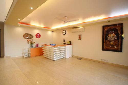 een lege kamer met een bureau en een schilderij aan de muur bij Collection O 8704 Hotel Sakshi in Gurgaon