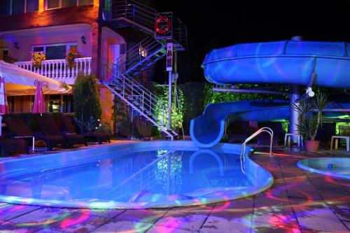 a swimming pool at night with a water slide at Комплекс за гости "Тера Верде" in Oreshak