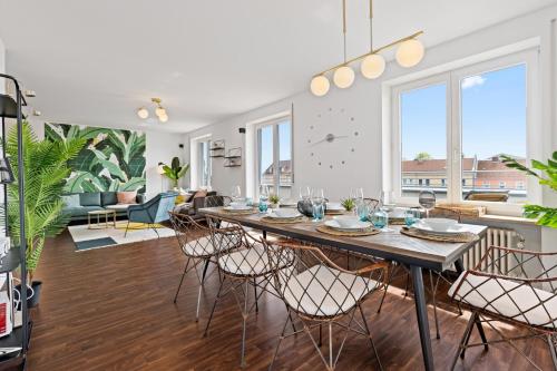 a dining room and living room with a table and chairs at Arbio I Premium Penthouse Apartment Augsburg in Augsburg