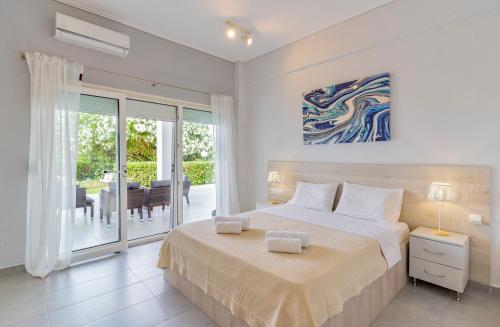 a white bedroom with a bed and a dining room at Seashell by halu! in Nea Fokea