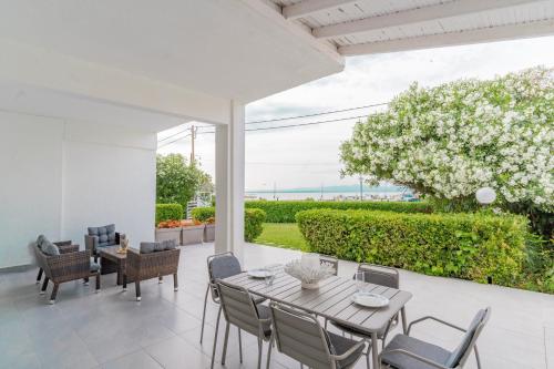 a dining room with a table and chairs on a patio at Seashell by halu! in Nea Fokea