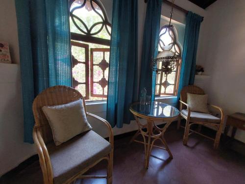 a dining room with a table and chairs and a window at Marbella Guest House in Sinquerim