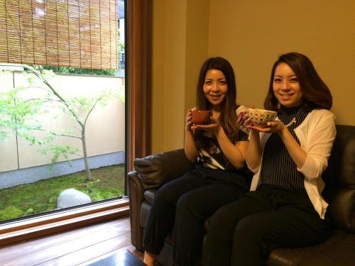 two women sitting on a couch looking at their cell phones at Kyo no Yado Sangen Ninenzaka in Kyoto