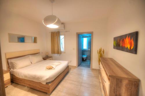 um quarto com uma cama com um gato deitado sobre ela em Spacious & modern 3 bedroom near seafront JBOR1-1 em Il-Gżira