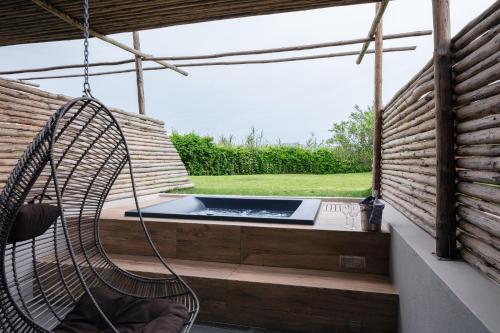 a swing on a porch with a hot tub at La Mer Resort Spa Crete in Georgioupolis