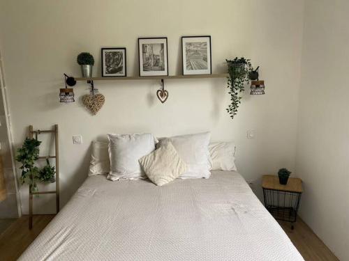 - une chambre dotée d'un lit avec des draps blancs et des photos murales dans l'établissement Maison à la campagne avec piscine et jacuzzi, à Cadouin