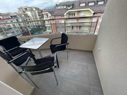 balkon z krzesłami i stołem oraz niektóre budynki w obiekcie Hotel Majestic w mieście Struga