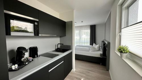 una cocina con armarios negros y una cama en una habitación en CAP1 Boardinghouse en Baesweiler