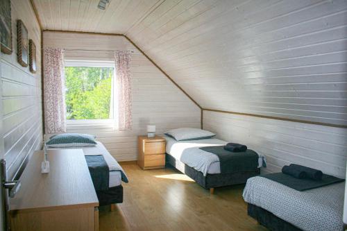 ルビャトボにあるLubiatowo Źródlana 10のベッド2台と窓が備わる屋根裏部屋です。