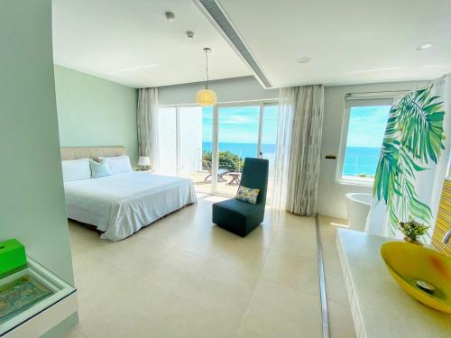a bedroom with a bed and a view of the ocean at Kenting Ocean Paradise Resort in Hengchun South Gate