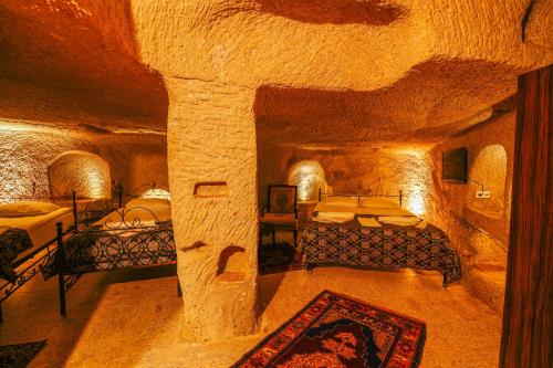 a room with two beds in a cave at Alaca Cave Suites in Goreme
