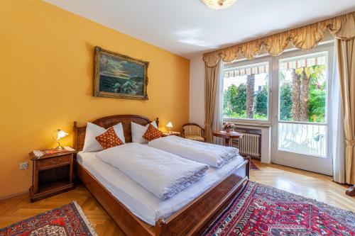 une chambre avec un lit et une grande fenêtre dans l'établissement Villa Coris Ferienwohnung Magnolia, à Merano