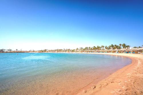 a beach with a group of umbrellas and the ocean at Labranda Royal Makadi in Hurghada