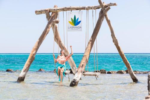 une femme assise sur une balançoire sur la plage dans l'établissement Labranda Royal Makadi, à Hurghada