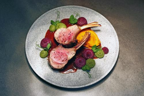 a plate of food with meat and fruit on a table at The Verdandi Hotel in Oslo