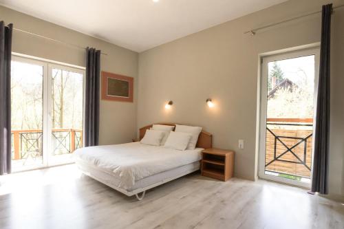 a bedroom with a bed and two large windows at Wysokie Horyzonty in Karpacz
